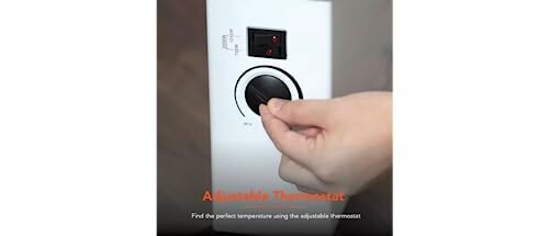 Hand adjusting a thermostat dial