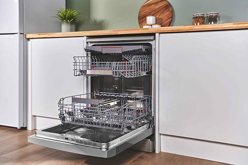 Open dishwasher in a modern kitchen with wooden countertop.